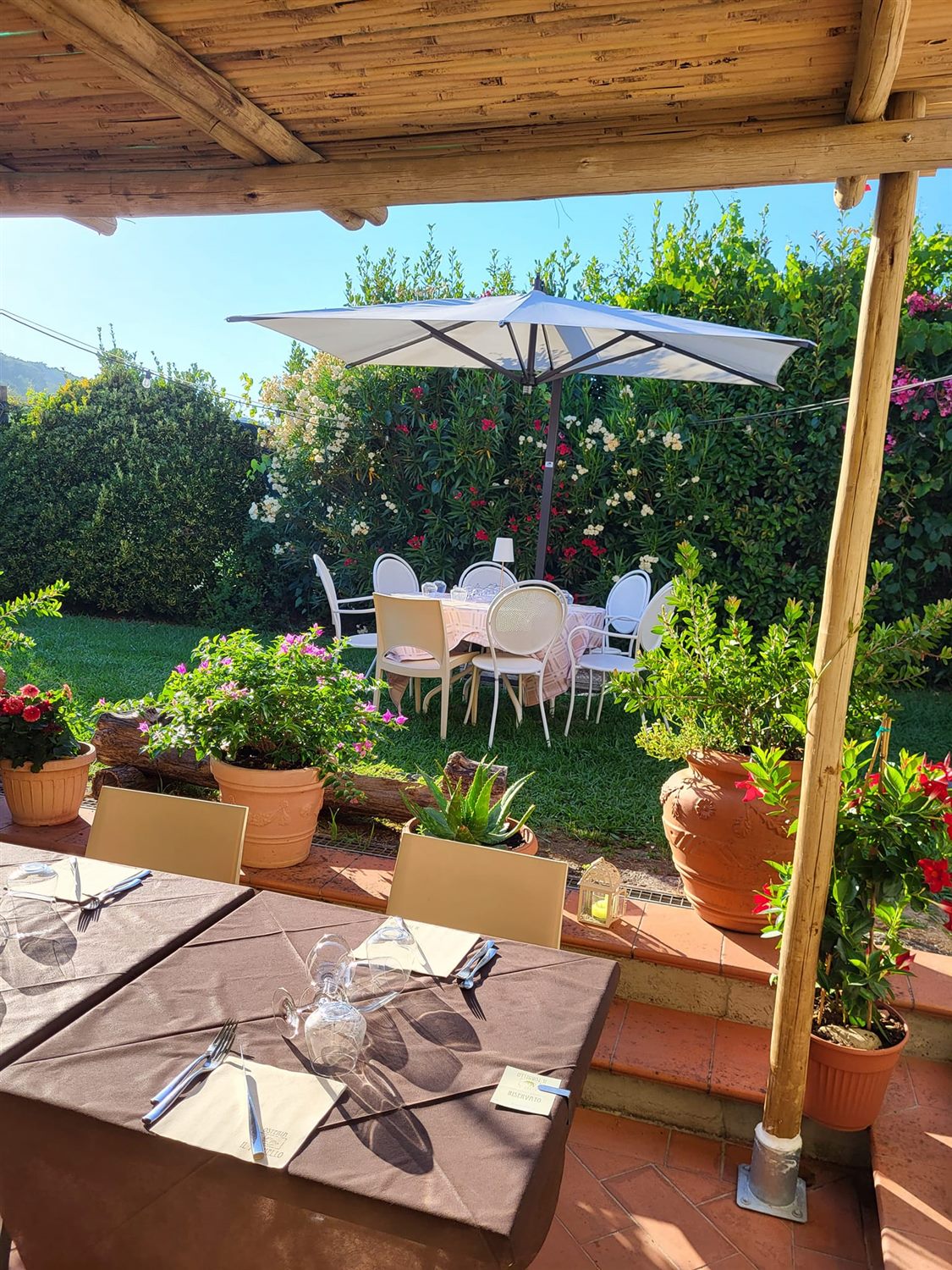 Tavoli del giardino dell'Osteria Il Fornello all'ombra degli alberi