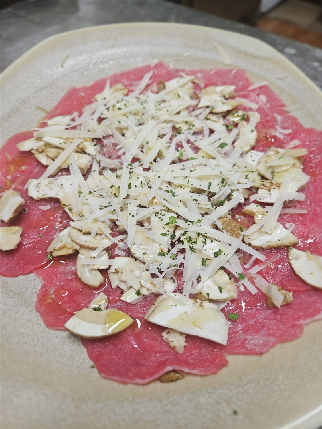Carpaccio di manzo con grana e porcini dell'Osteria Il Fornello